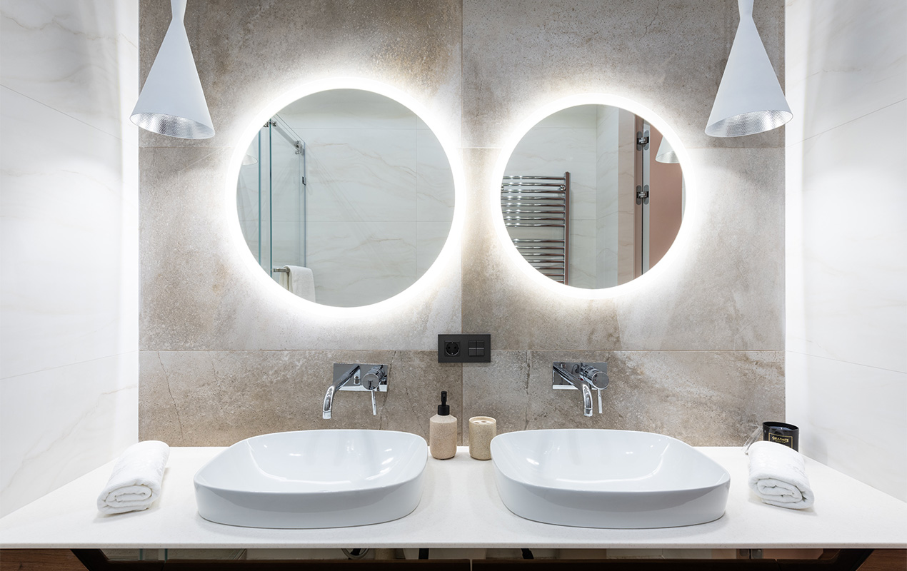 His and Hers wash basins with two lighted mirrors and tiled walls
