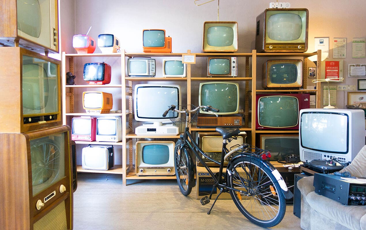 A vintage store with televisions and a bike