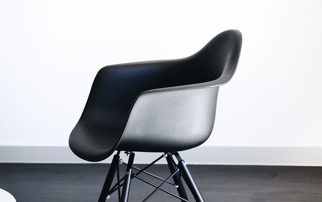 A black bucket chair with a white background.