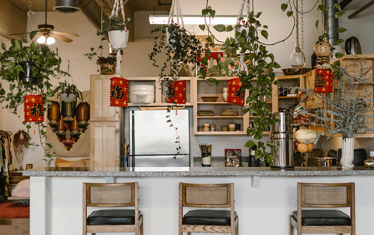 Kitchen design with hanging baskets, wooden chairs and a breakfast bar