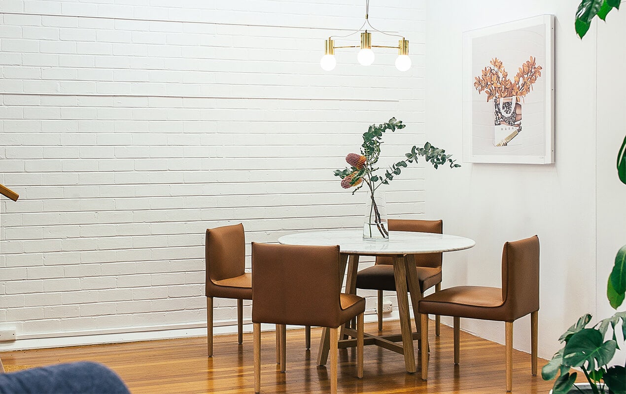Home interior with exposed brick wall, table, and chairs