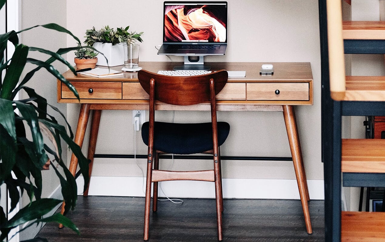 Vintage wood desk and char with a laptop and plant decor