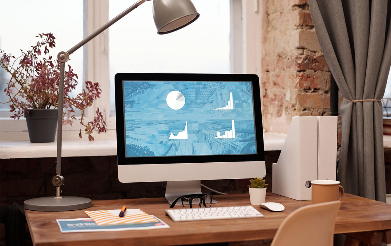 Wooden desk with computer and work essentials