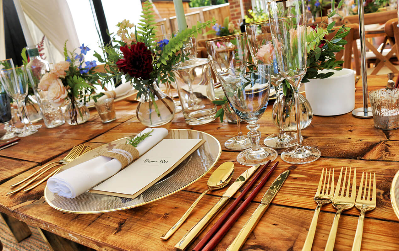 Wooden dining with glasses and gold cutlery