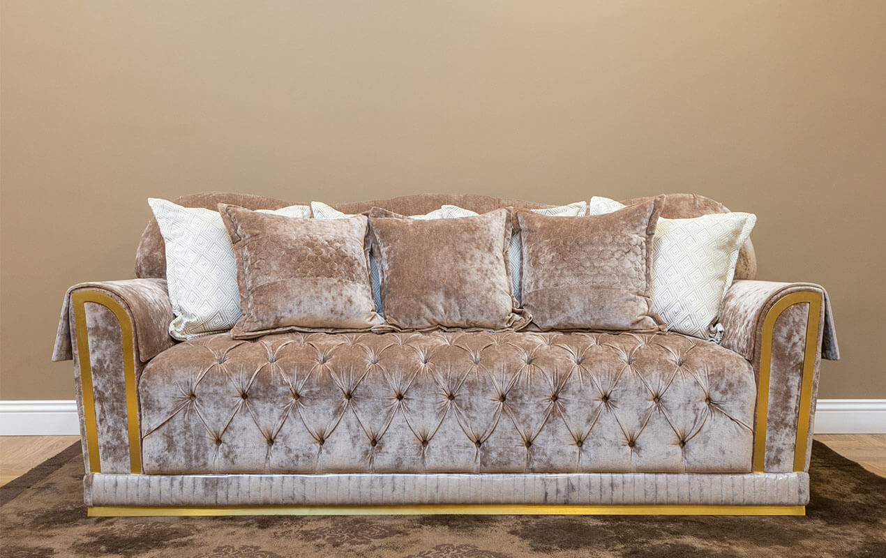 A velvet sofa in a neutral color on a floor rug
