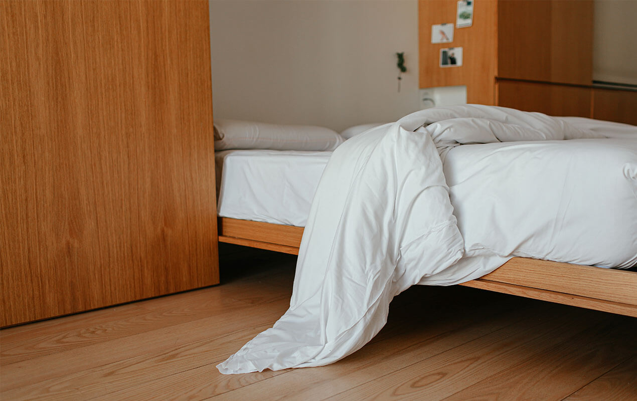 Bedroom interior with white bed sheets.