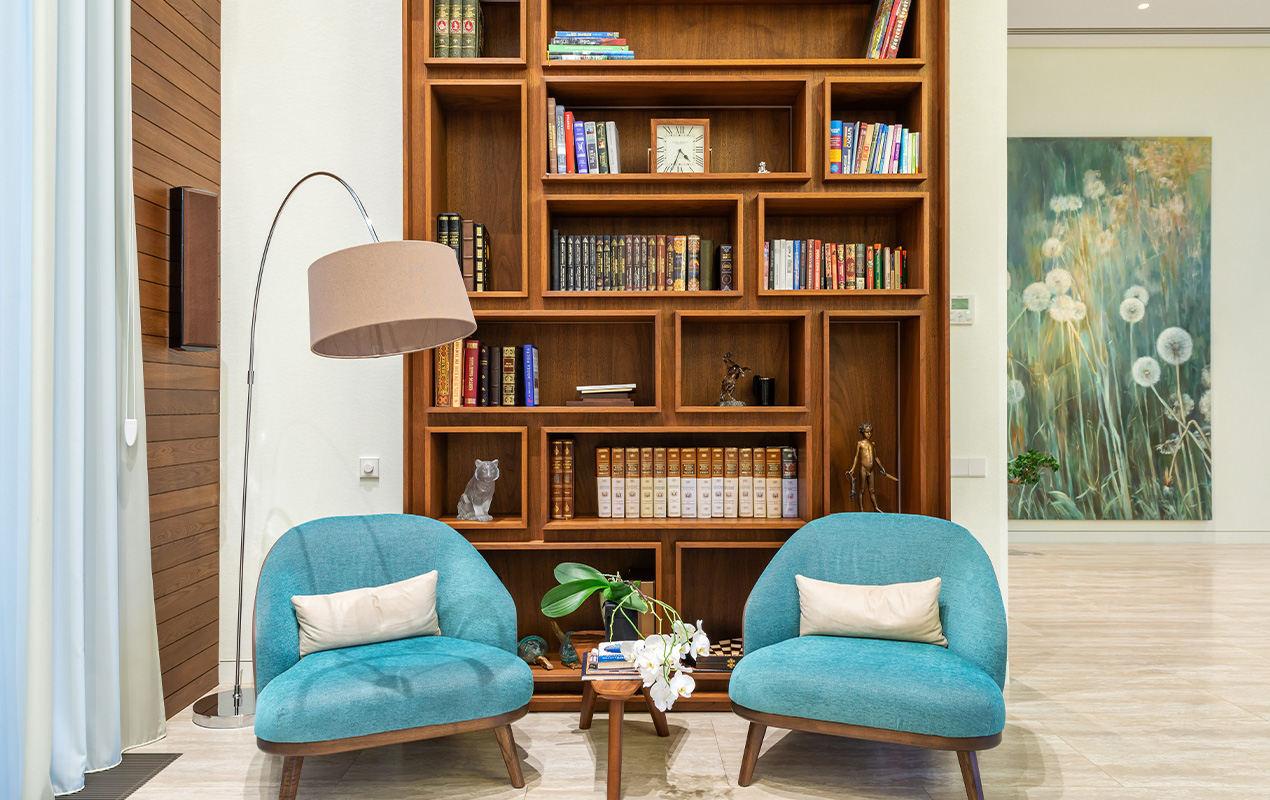 Interior bookshelf with chairs and a floor lamp