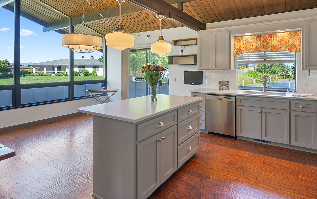 Gray kitchen island with white countertop by DeCasa Collections