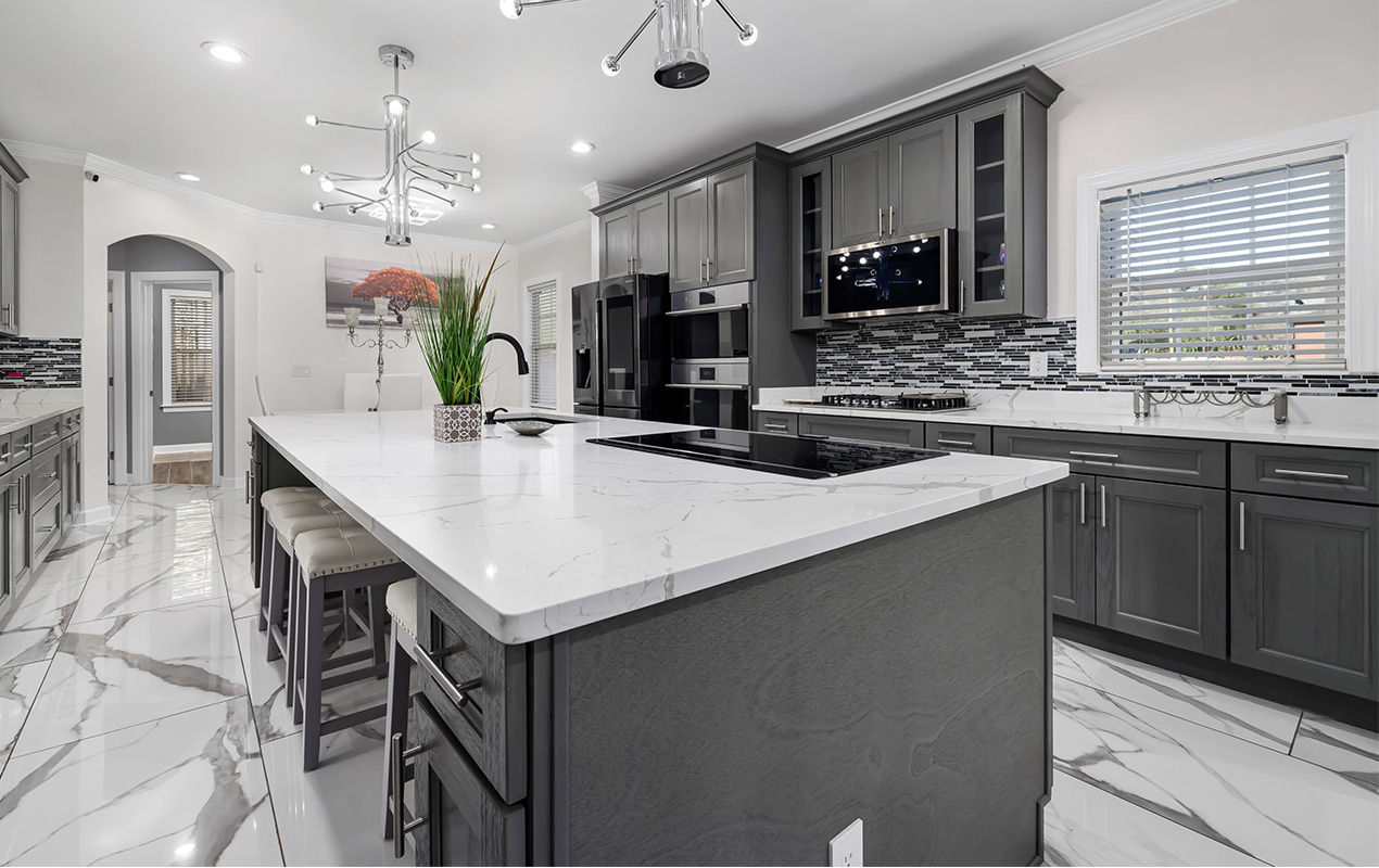 Black kitchen with sink and granite countertop by DeCas Collections