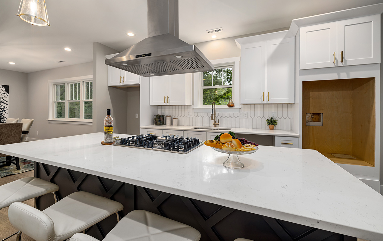 Large kitchen with white countertops by DeCasa Collections