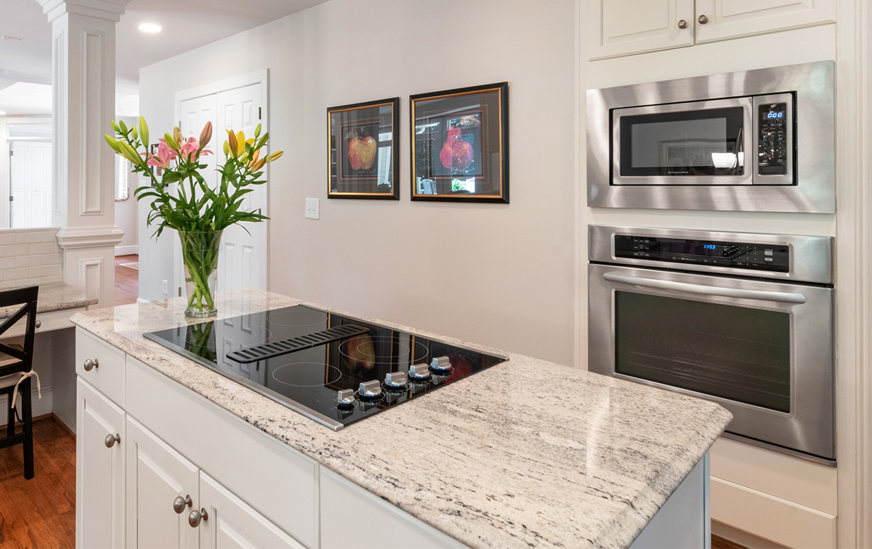 White interior with integrated kitchen appliances by DeCas Collections