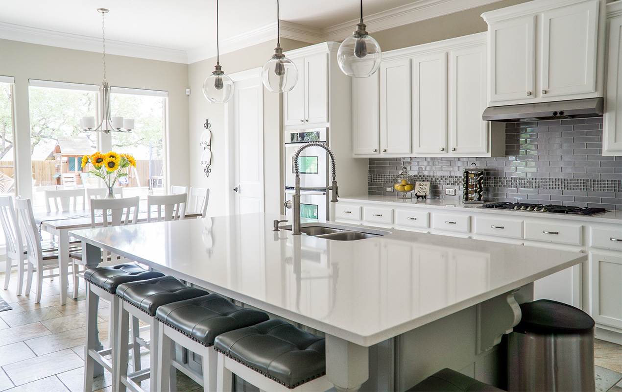 White interior kitchen with white and gray stools by DeCasa Collections