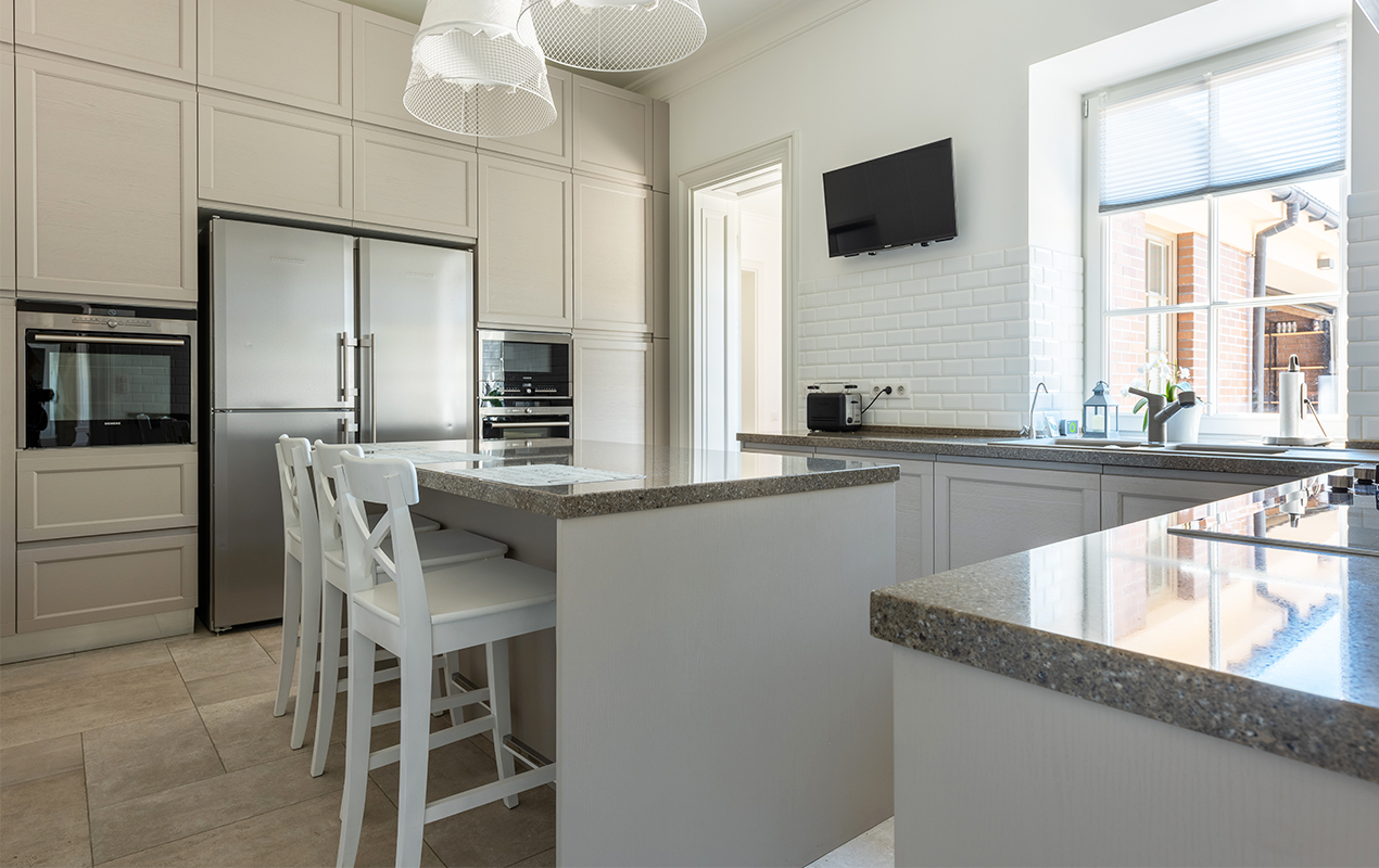 Kitchen with paneled interior wall and white high back chairs by DeCasa Collections