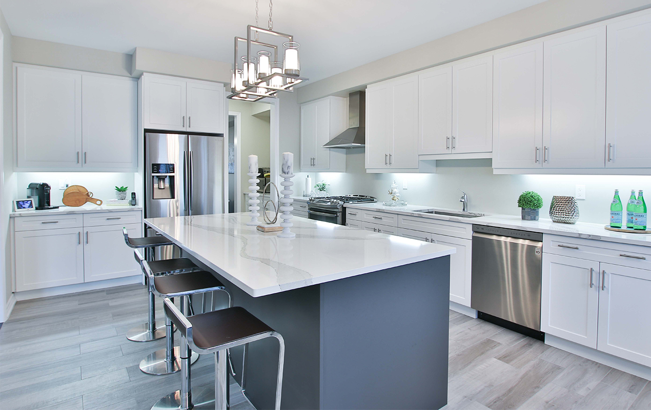 Gray and white kitchen island with steel stools by DeCasa Collections