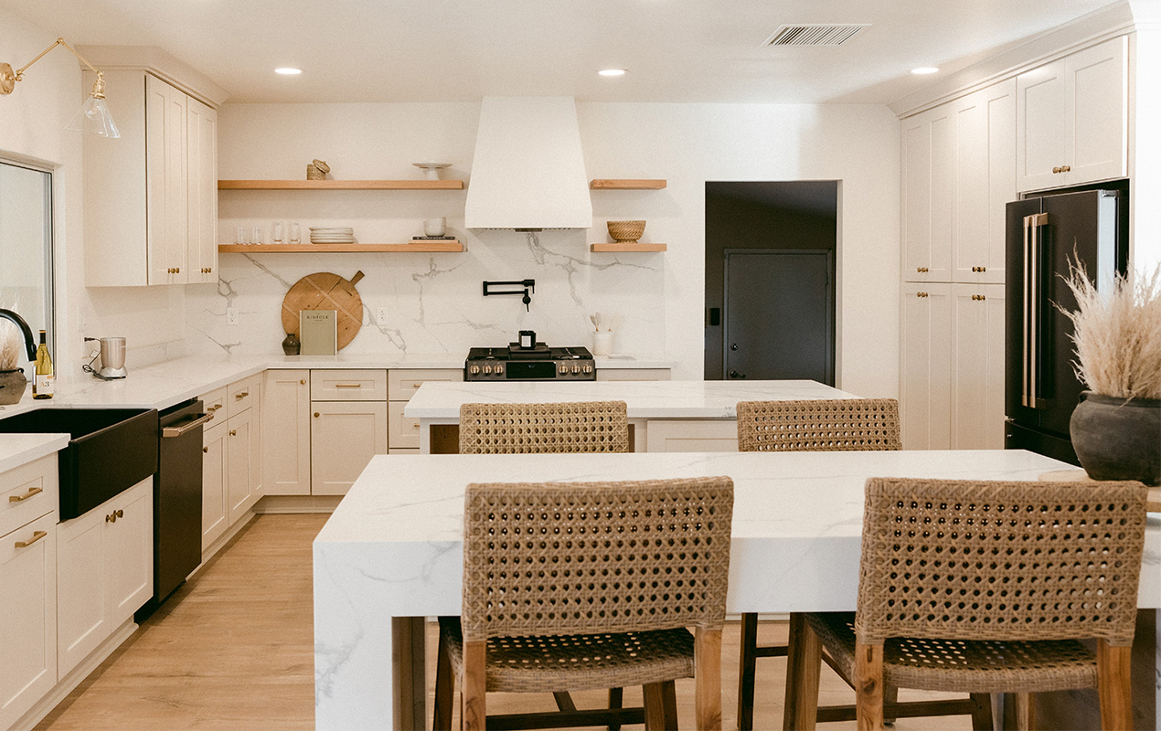 White marble kitchen island with rattan chairs by DeCasa Collections