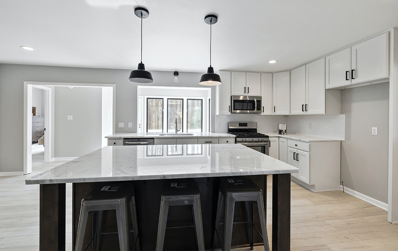 Gray kitchen with black island by DeCasa Collections``