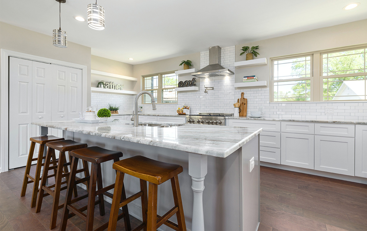 White and gray kitchen island with stools by DeCasa Collections