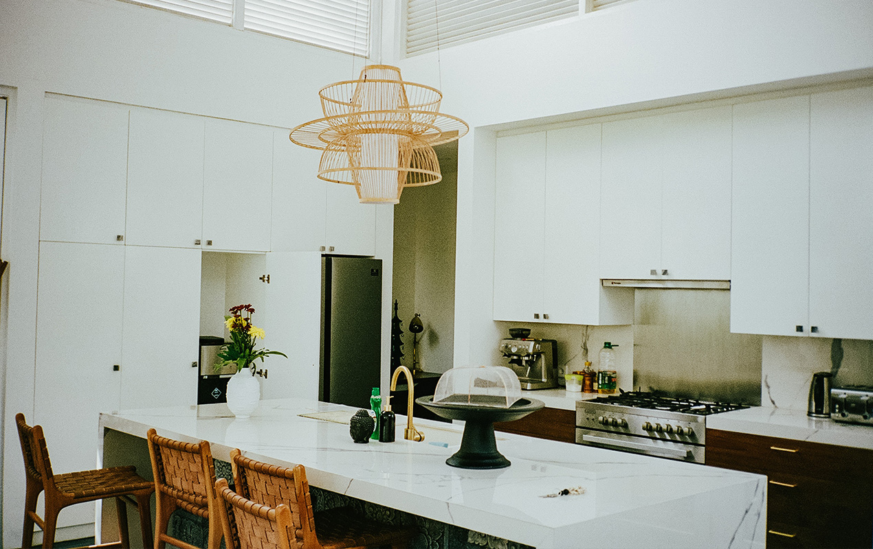 White kitchen interior with gold lighting by DeCasa Collections