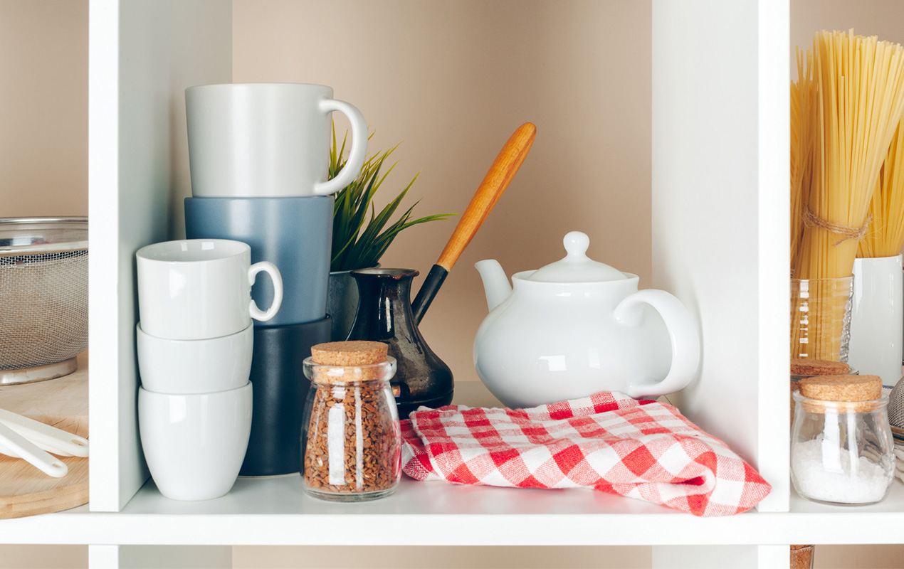 Utensils, mugs, kitchenware on open shelves