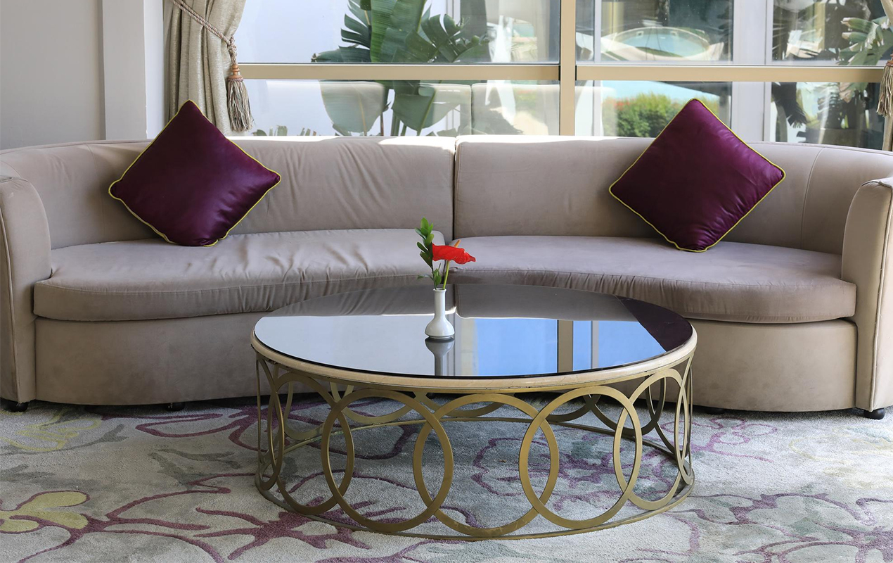 Gold coffee table pink couch and purple cushions
