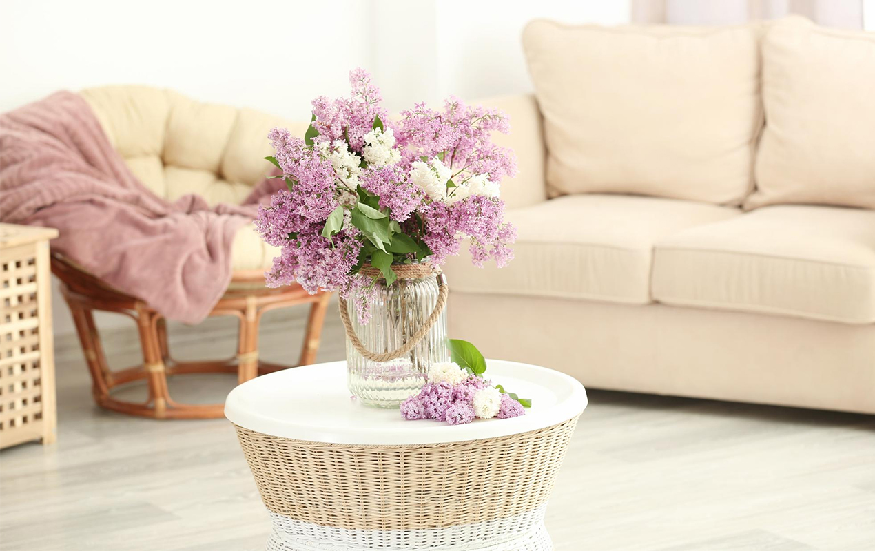 Glass vase with beautiful lilac flowers table
