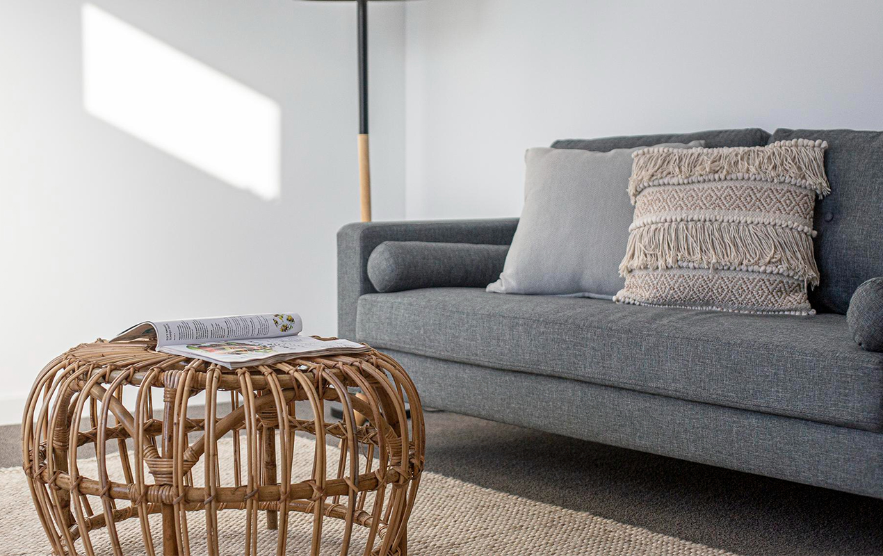 Living room with gray sofa and wicker coffee table
