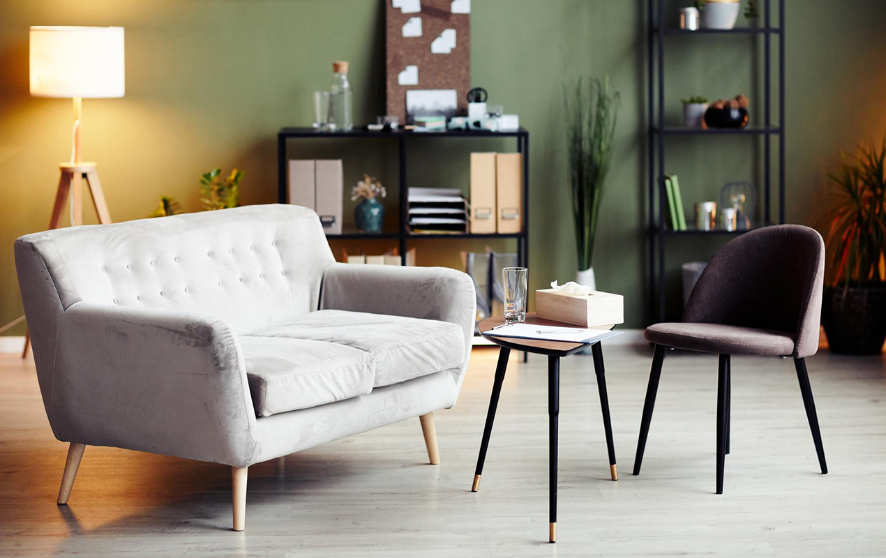 Green interior walls with gray couch and small coffee table