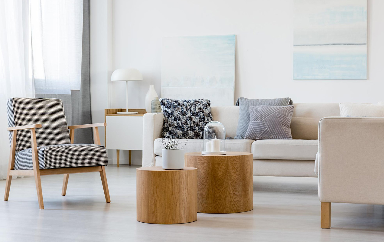 Two wooden coffee tables with plant pot front gray corner sofa