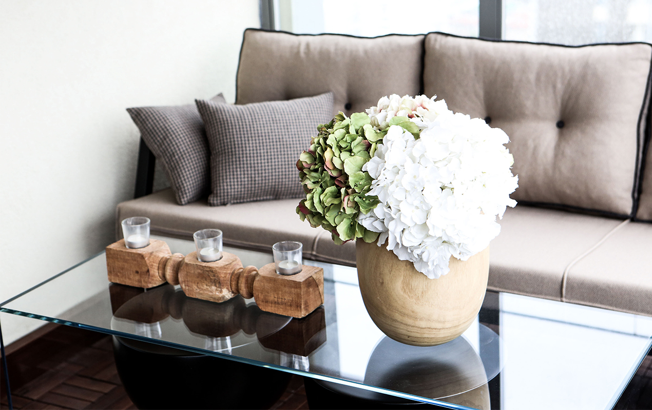 A Coffee Table Adorned with Scented Candles and Vibrant Blooms