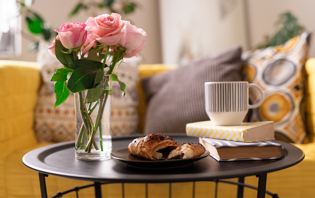 Coffee Table Fashion with Pink Roses, Croissants, Coffee, and Books