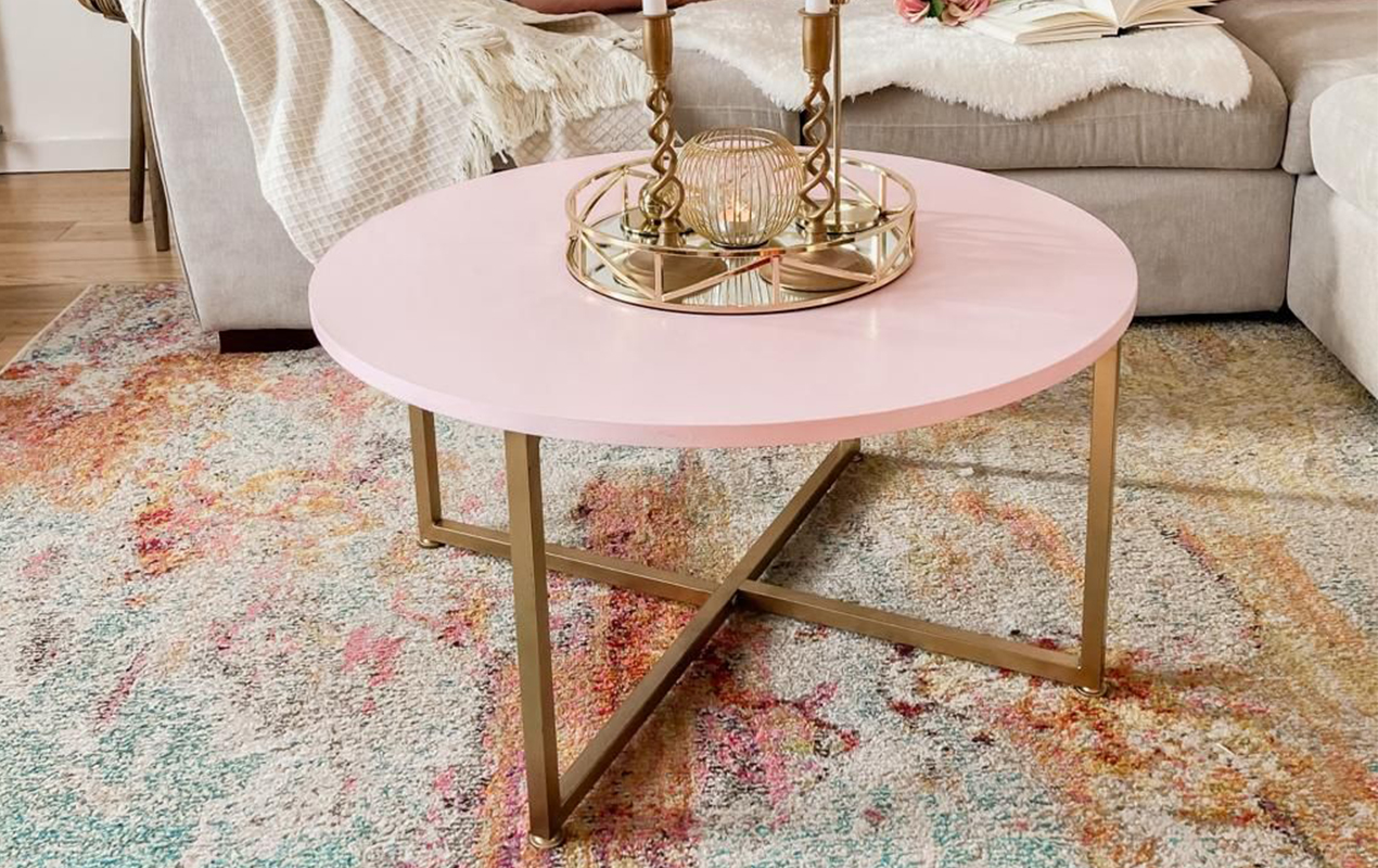 Luxurious Poise: Pink Marble Coffee Table, Modern Gray Sofa, and Vibrant Rug in a Balanced Living Room