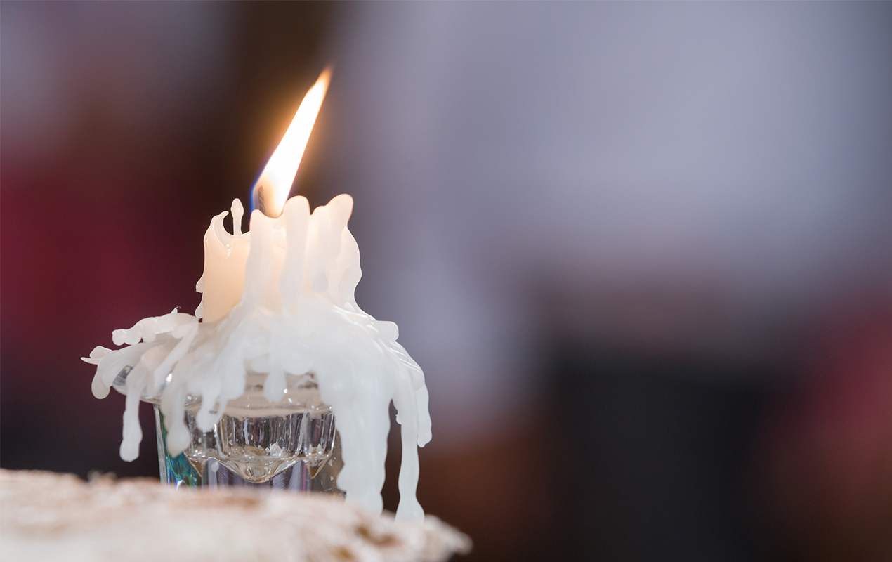 Candle with holder and overflowing wax